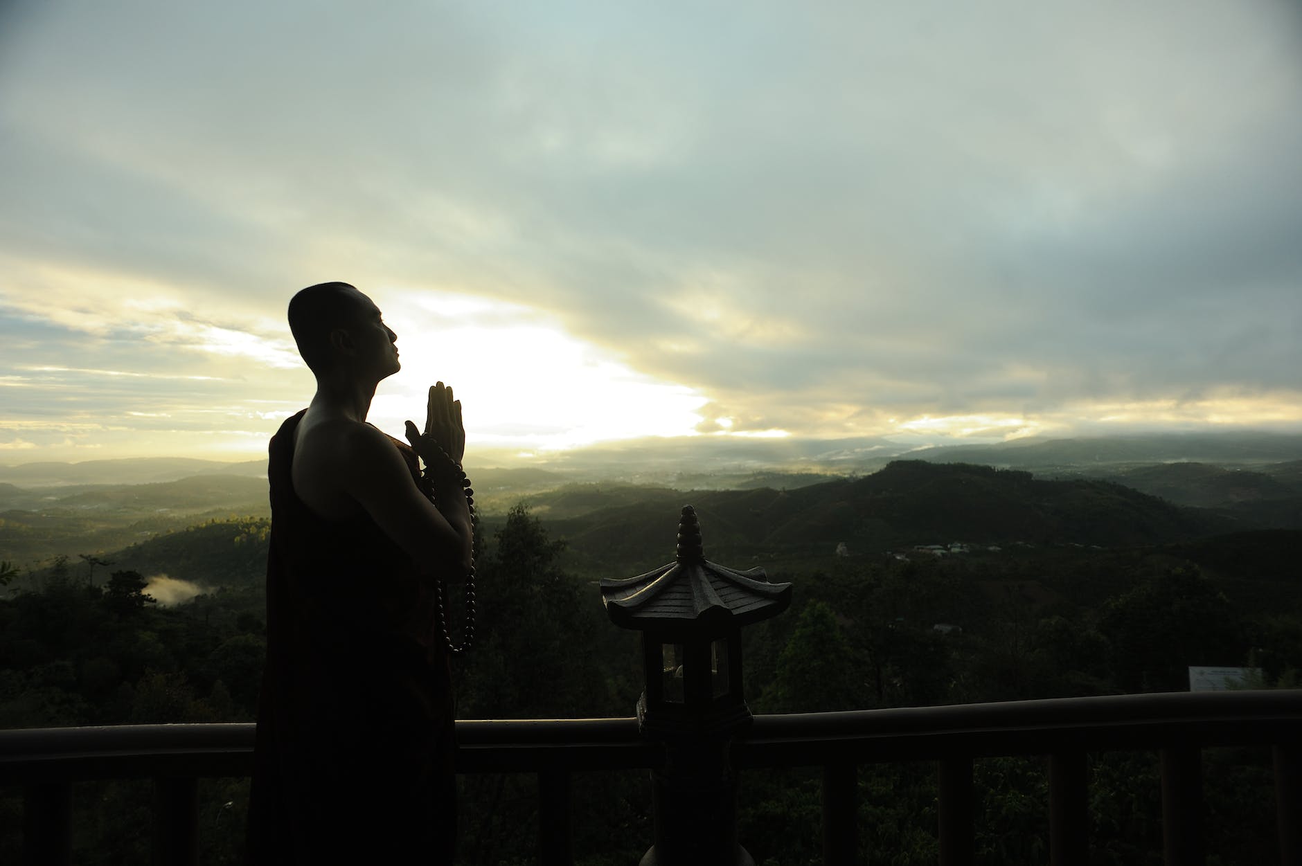 monk holding prayer beads across mountain, 777 meaning manifestation