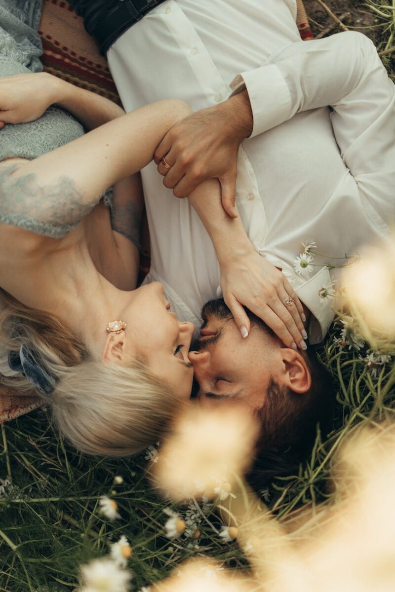 romantic couple lying down on grass next to each other